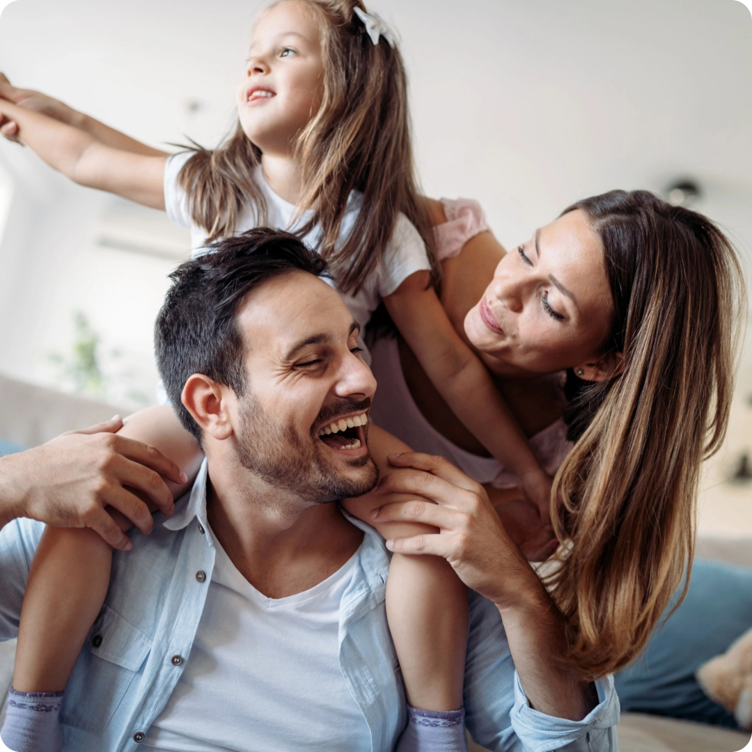 Happy family smiling together with daughter on father's shoulders